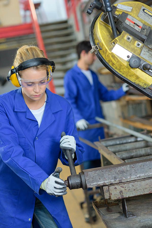 Female worker wearing ear protection while working in noisy environment