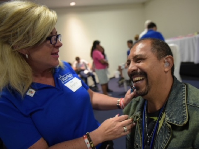 Annette Cross with a gentlemen with hearing loss problems smiling together